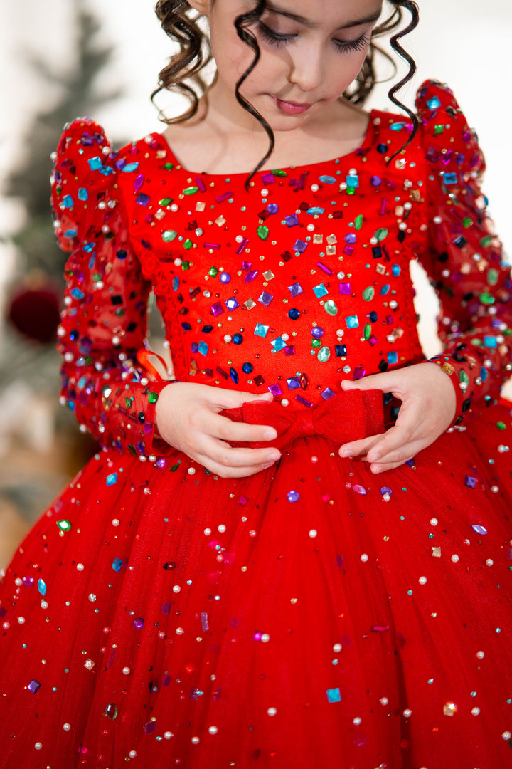 Child wearing a red dress with colorful sequins in a festive setting
