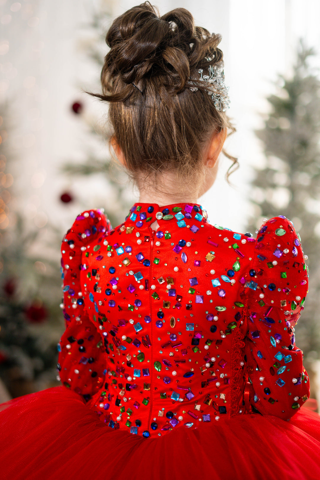 Red dress with colorful sequins and a blurred Christmas tree background