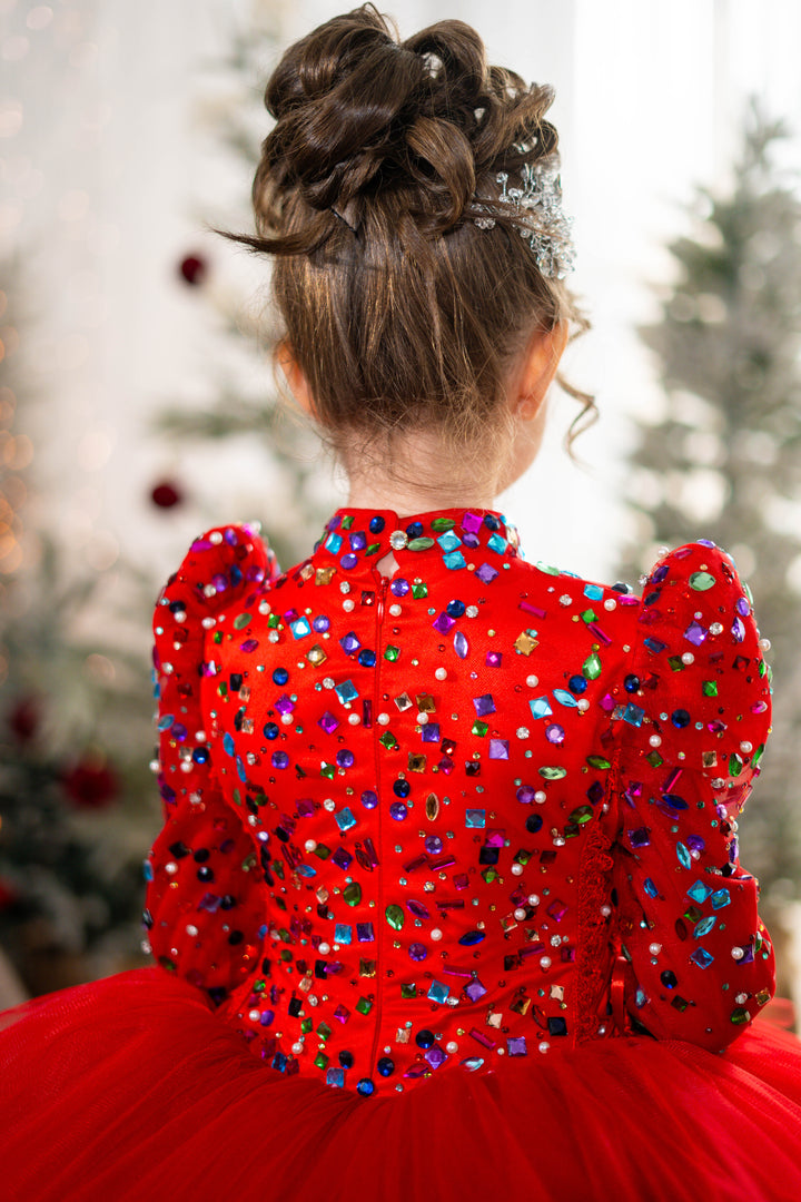 Red dress with colorful sequins and a blurred Christmas tree background
