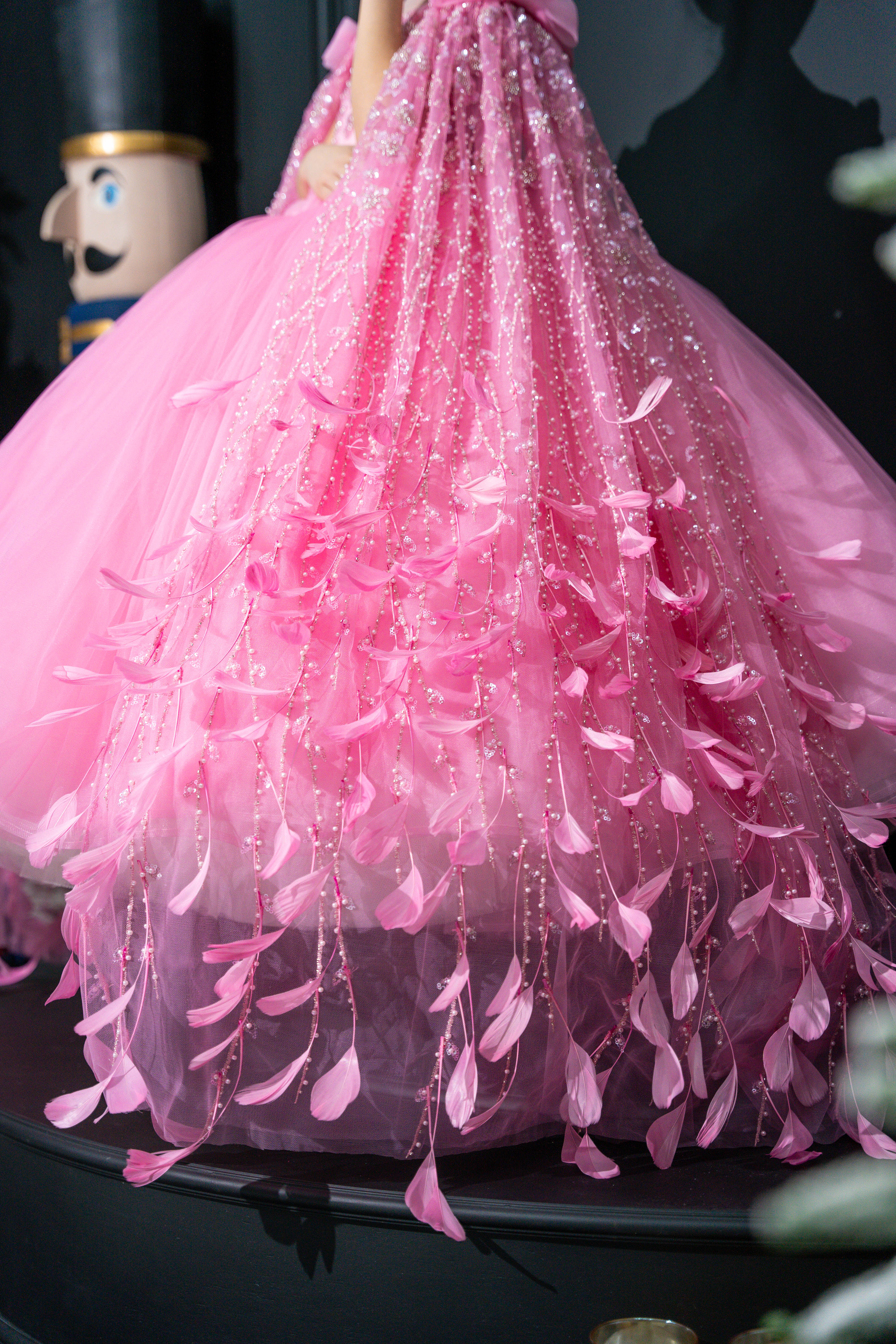 Close-up of a pink baby dress with ruffled layers on a dark background